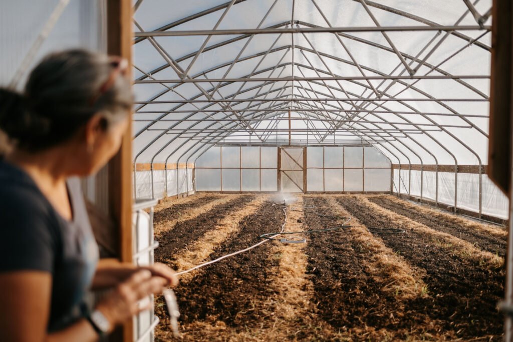 Sharon Autry looking into an empty greenhouse