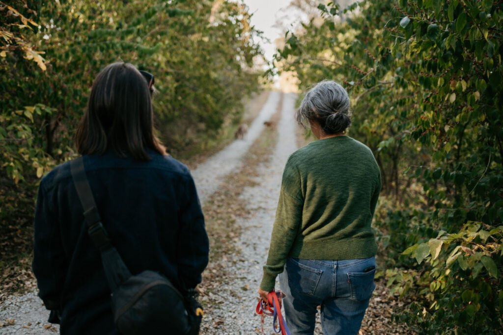 Shaon Autry walking down a gravel driveway with another woman and two dogs.