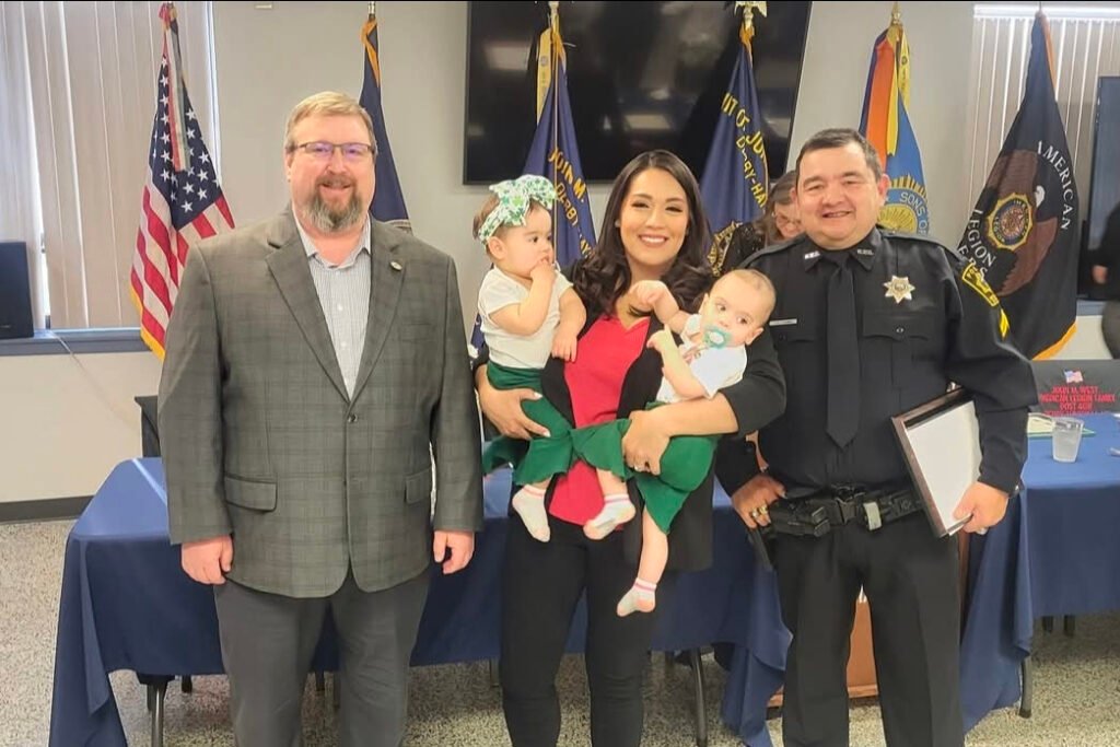 Sarah Lopez holding her twins with two Sedwick county employees.